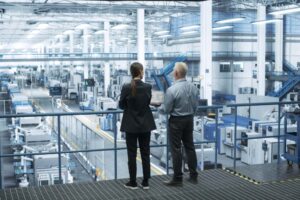 Two engineers overlooking an electronics manufacturing facility.